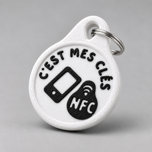 Round white plastic NFC keychain with black raised text reading c'est mes clés and an NFC icon on a metal ring.